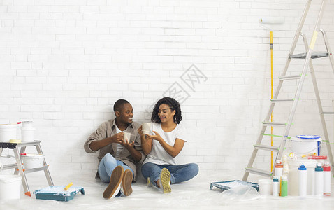 年轻的非洲爱情夫妇坐在室内新公寓里带油图片