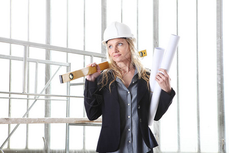 带精神水平仪的女建筑师或建筑工程师戴头盔图片