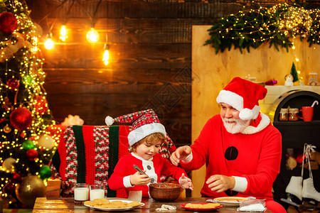 父亲和儿子在木屋背景上制作圣诞饼干圣诞老人帮手小圣诞老人给圣图片