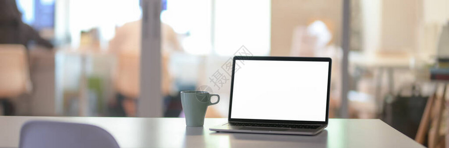 用空白屏幕笔记本电脑和玻璃隔间白桌上咖啡杯制成的办公背景图片