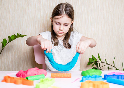 一个学龄前女孩在玩彩色粘土自制塑料橡皮泥玩面团塑造型粘土的女图片