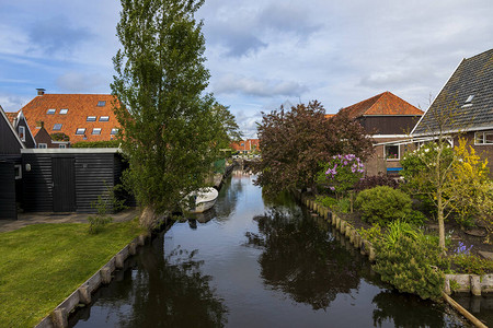 荷兰Hindeloopen房屋之间的水渠有一艘船在水上图片