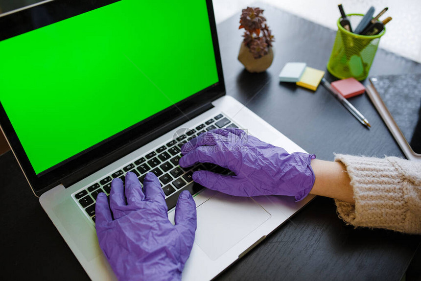 验尸官的概念双手戴着紫色防护手套在笔记本电脑键盘上打字带绿屏的设备隔离社会隔离待在家图片