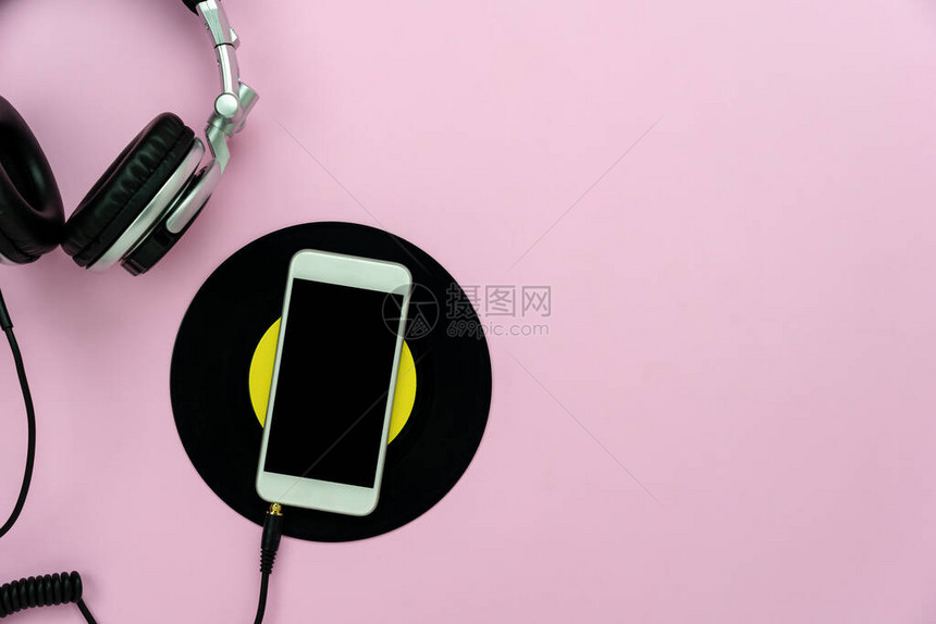 音乐和技术概念的桌面视图现代质朴的桌子上的白色智能手机与耳机和音乐磁盘在家庭办公桌上的平躺复制空间图片