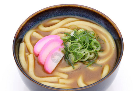 白色背景碗中日本咖喱乌冬面的特写图片