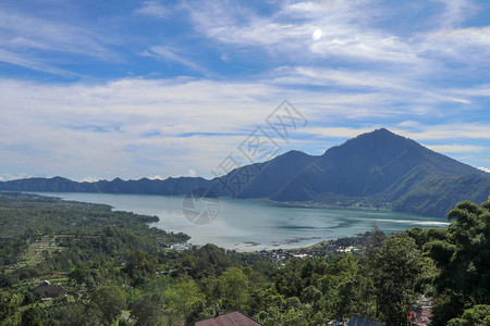 印度尼西亚巴厘岛阿邦山下巴杜尔火山口的山湖大型饮用水库的安静水平高的山峰耸立在背景图片