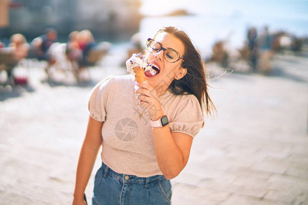 在度假的年轻美女微笑着快乐和自信站着面笑着在城里吃冰淇图片