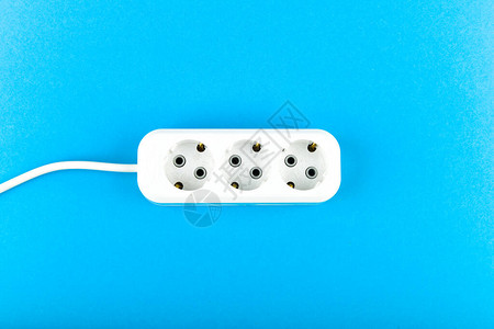 带电线的白色插座从上面查看蓝色背景上白色插座和延长线带长螺旋线的三个图片
