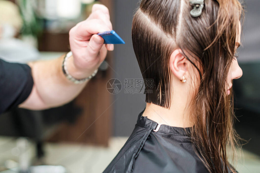 美发师在美发沙龙用梳子理女头发图片