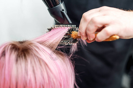 美发师的手正在干短粉色头发一根图片