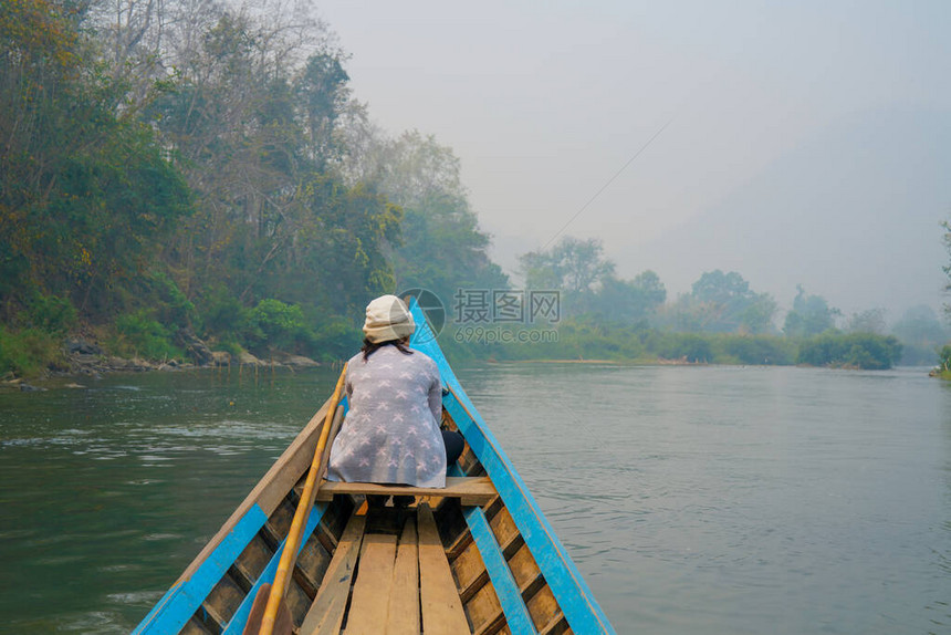 小木船在绿色丛林中的野生热带河流中航行图片