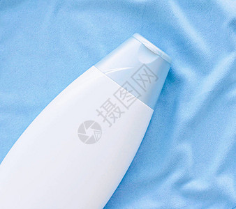 蓝丝底美容产品和身体护理化妆品平板上贴白标签的洗发水瓶或图片
