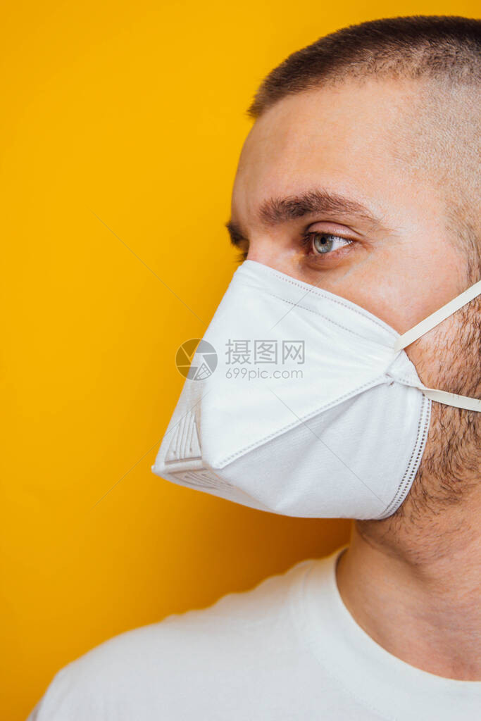 新冠黄色背景上戴着呼吸器的年轻人保护口腔和眼睛免受感染废气的侵害预图片