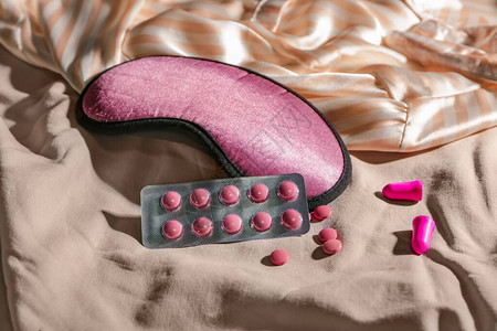 床上的睡眠面膜和药丸图片