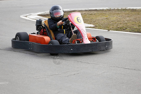男孩在游乐场赛道上快速驾驶高卡特车戈卡特是流行的图片