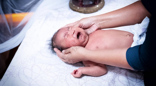 治疗师对新生婴儿身体进行按摩图片