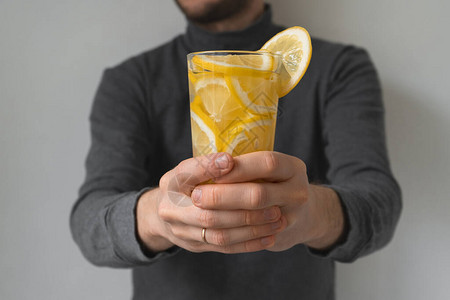 柠檬冰沙和维生素C一个男人的手拿着一杯水图片