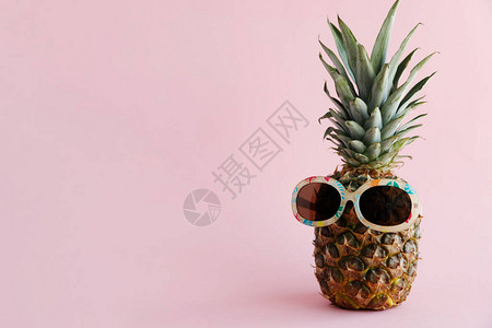 太阳镜中的新鲜菠萝代表着粉红色背景图片