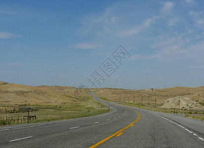 沿着怀俄明州的平原和山谷铺设的蜿蜒道路图片
