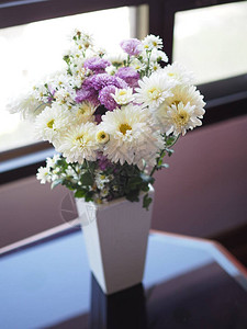 白色陶瓷瓶中美丽的花朵紫色图片
