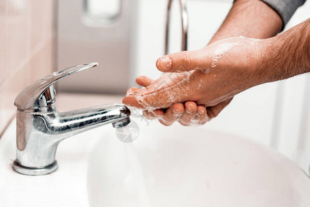 在公共场所的水槽中用肥皂洗手卫生概念用水在龙头图片