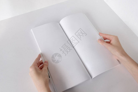 白色小册子模拟垂直格式空白小册子一个女人拿着一张有空白页的相册图片