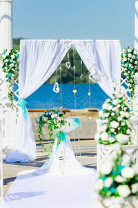 用布和鲜花装饰的婚礼拱门湖岸图片