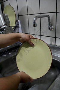 萨尔瓦多市厨房水槽里的人洗盘子图片