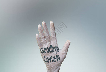 戴着医用手套的手掌上再见covid19图片