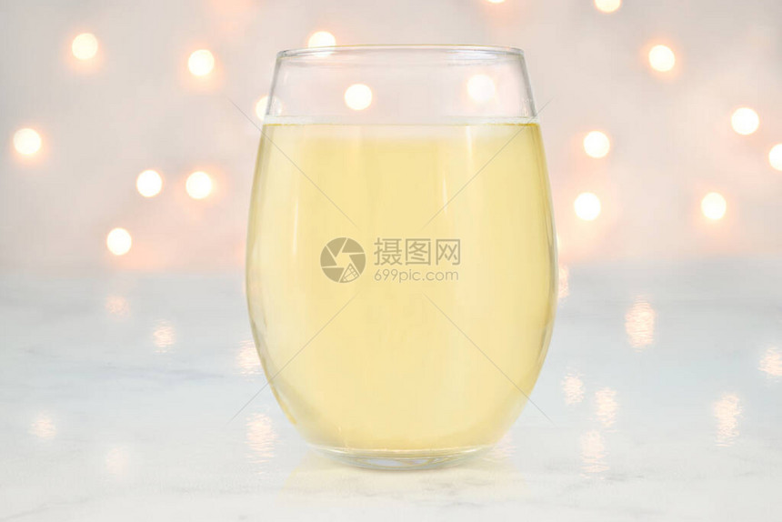 NoStemWineglass样机以一个装满白葡萄酒的无柄酒杯为特色白色的灯光在背景中散发图片