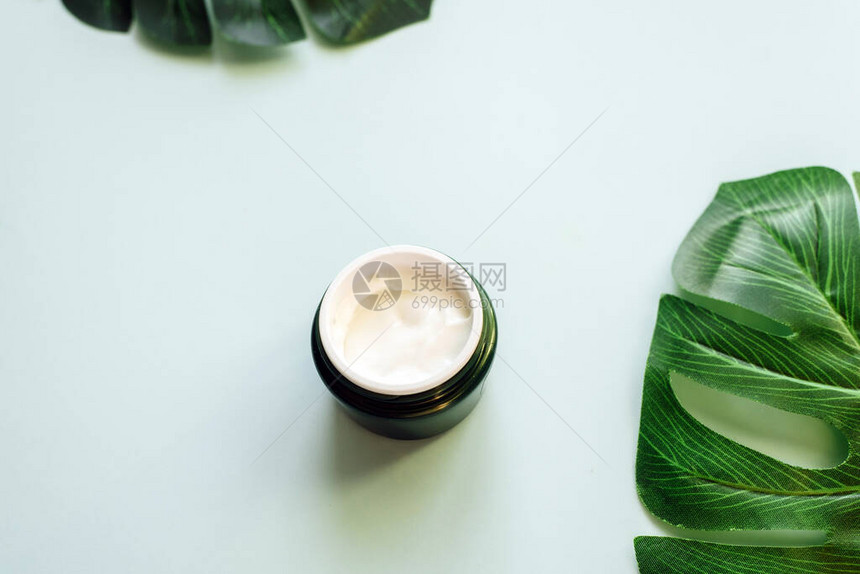 在新鲜棕榈叶背景下的润滑剂天然化妆品来自天然成分的概念图片