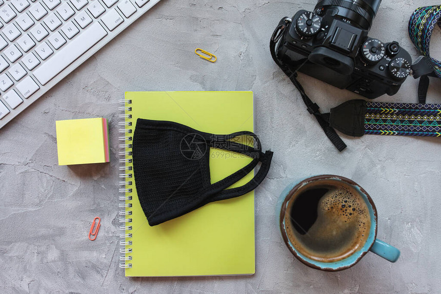 红粉面罩照相机键盘笔记板和咖啡杯Corona的爆发在家庭概念中起作用顶端视图平图片