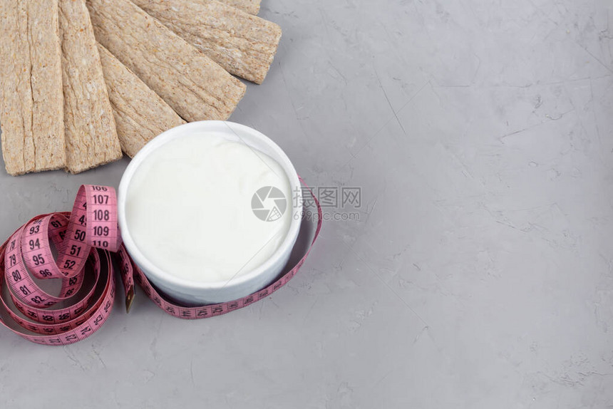 在浅色背景上带麸皮的减肥脆饼近一厘米和自制酸奶减肥的概念健康饮食素饼图片