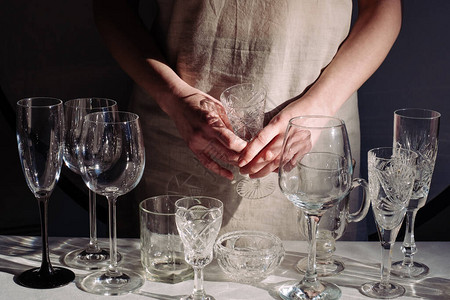 女人的手在黑色背景的桌子上放着不同的酒杯很多玻璃杯的饮料图片