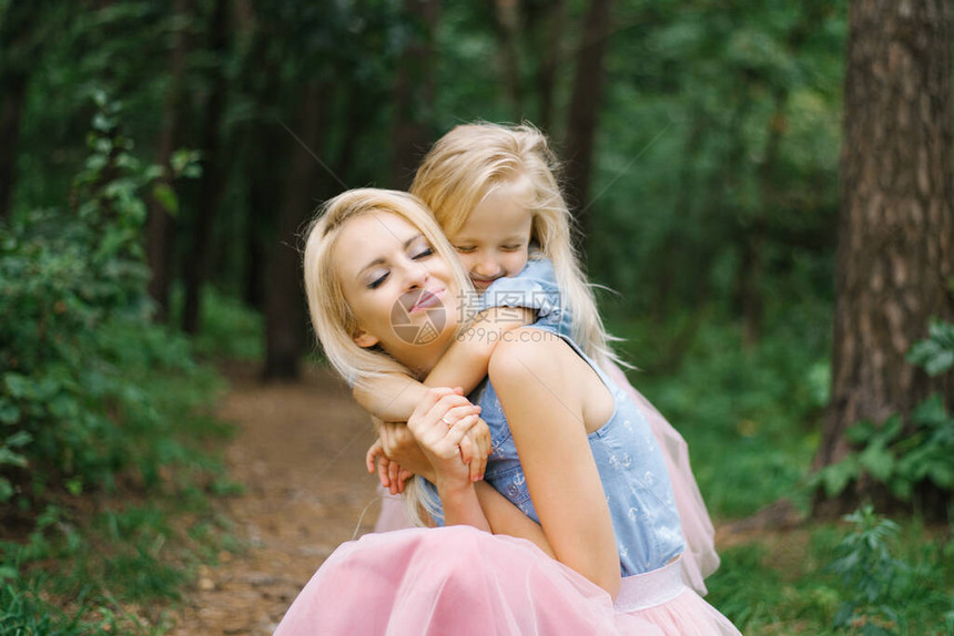 一位母亲和一位五岁的女儿穿着一模样的粉色薄纱裙和蓝色牛仔衬衫图片