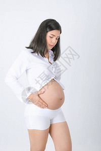 怀孕的快乐女人抚摸她的肚子图片
