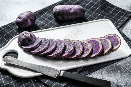 白色切片板上的紫菜土豆灰色背图片