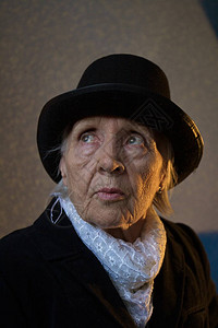 外婆穿着黑色时装帽子和白围巾抬头看她图片