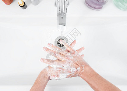 女人在浴室的水龙头下用肥皂洗手卫生和消毒产品详细的卫生概念顶视图片