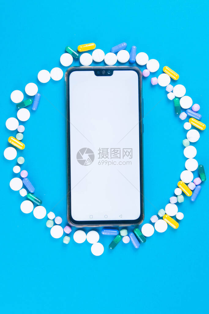 大量药片围绕着蓝色背景的电话制药行业的高分辨率图像移动应用具有清晰图片
