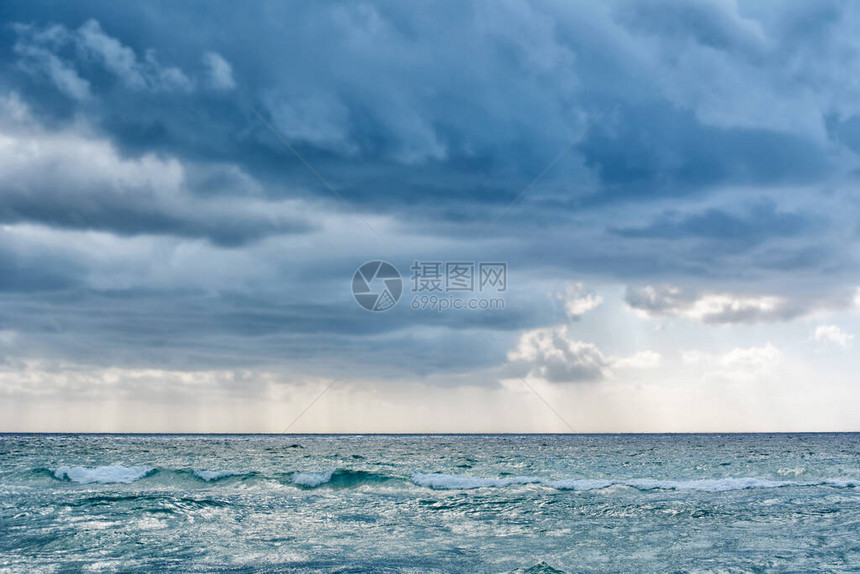 蓝色海岸的景色与暴风云和日落光图片