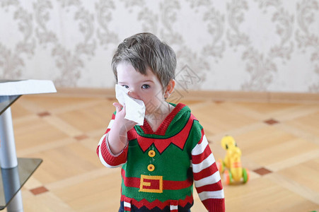 一个病男孩用餐巾纸擦鼻子的肖像流图片