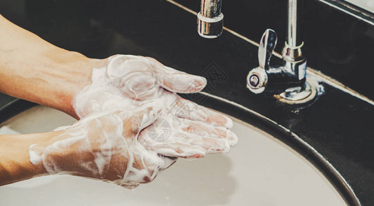用铬水龙头和肥皂近距离洗手图片