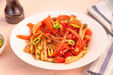 意大利菜白盘上加辣椒和洋葱的图片