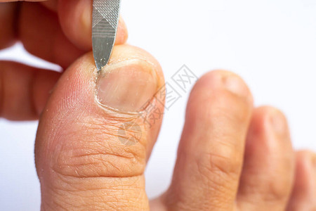 女用指甲锉清洁脚趾甲下的污垢图片