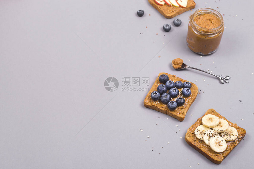 有花生酱水果和种子的三明治在灰色背景健康素食早餐顶层景色图片