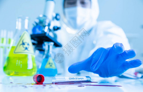 穿着连体工作服的科学家在实验室工作时对衣服进行消毒高清图片