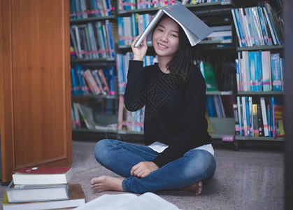 亚裔女学生在图书馆阅读书籍图片