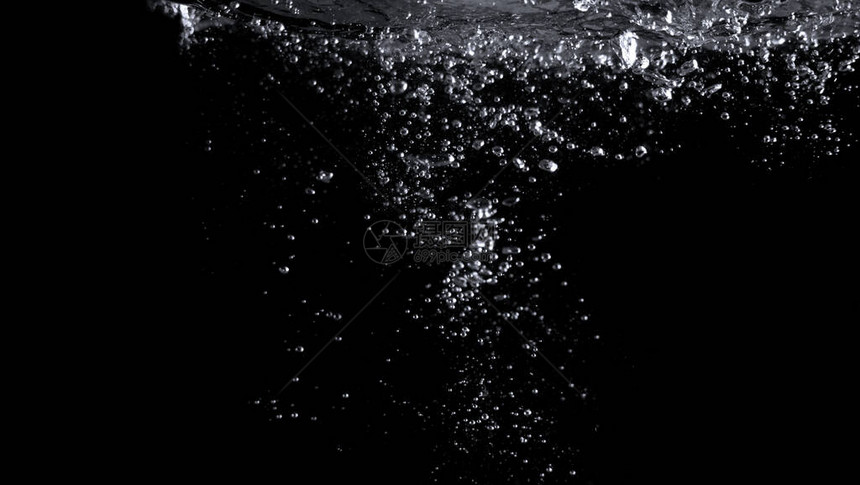 真实苏打气泡在黑色背景中漂浮和溅起的模糊图像图片