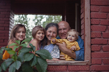 快乐的养老金领取者与孙子在村舍图片